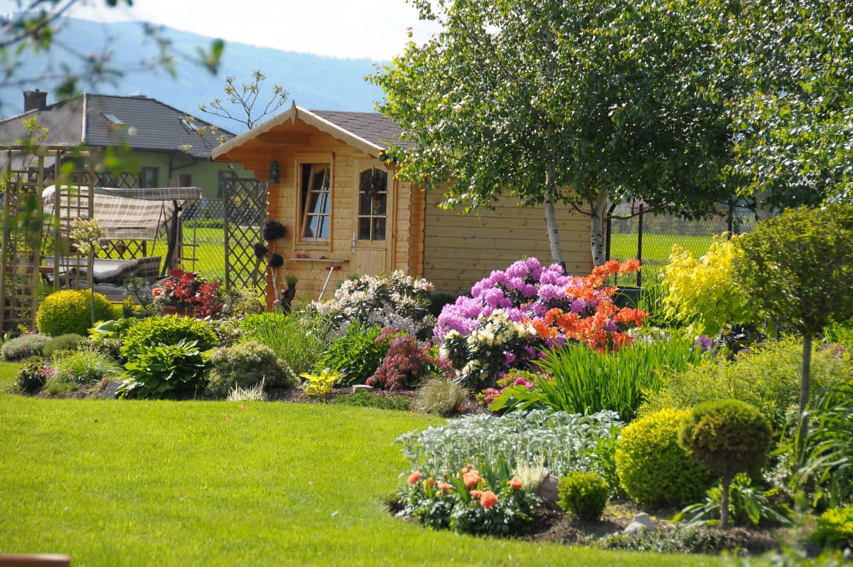 Planung und Gestaltung von Gartenanlagen - Foto zeigt einen grünen Garten mit einem Gartenhaus